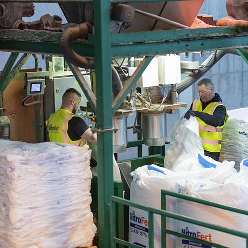 Two nitrofert workers filling large bags with fertiliser